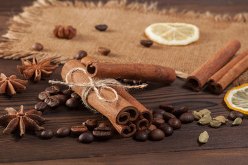 Cinnamon sticks, anise and dried lemon on sackcloth on a wooden background