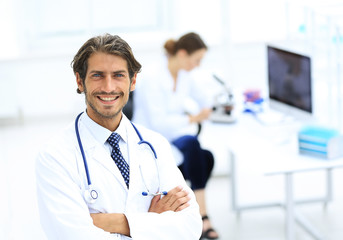 Handsome male doctor smiling with arms crossed on chest portrait