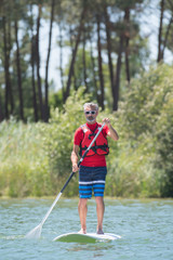 man enjoying a ride on the lake with paddleboard