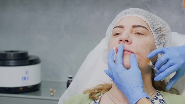 Beautician increase patient's lips with botox injection