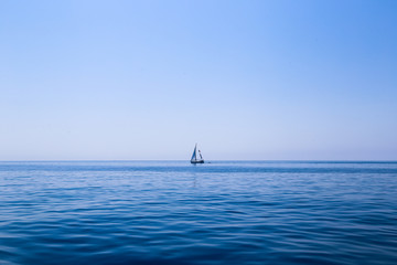 Fototapeta premium A Sail boat on the horizon at dusk in the Mediterranean Sea