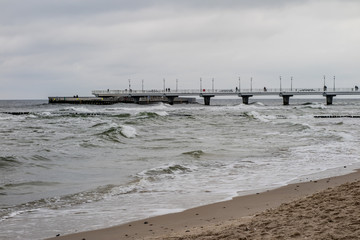 Fototapeta na wymiar Baltic Sea shore. The pier in Kołobrzeg seen from the side of lond.