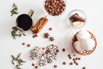 Black tea with cookies and cinnamon on a white wooden background