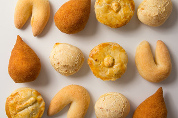 Assorted snacks: Pao de Queijo, Chipa, Coxinha and Empada. Group of typical food from Brazil. Top View, flat lay design on white background.