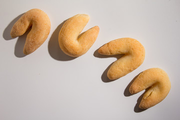 Cheese bread known as Chipa in Brazil, shaped like a horseshoe. Snacks over white background, minimalism.
