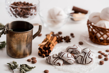 Black tea with cookies and cinnamon on a white wooden background