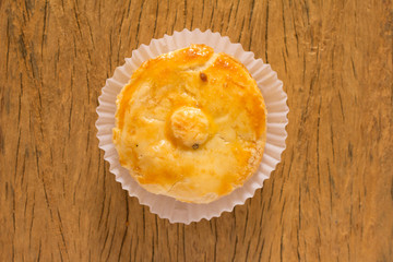 Stuffed chicken pie known as Empada in Portugal and Brazil. One snack on rustic wood table, top view.