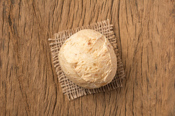 Pao de Queijo is a cheese bread ball from Brazil. Also known as Chipa, Pandebono and Pan de Yuca. One snack on rustic wood table, top view.