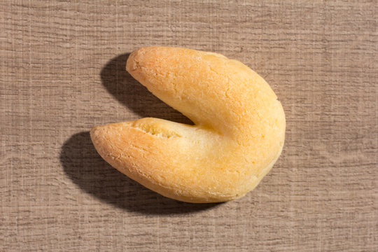 Cheese bread known as Chipa in Brazil, shaped like a horseshoe. Snack on wood table, flat design.