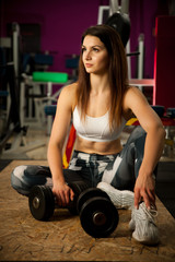 Fototapeta na wymiar active young woman rests after workout in fitness club gym