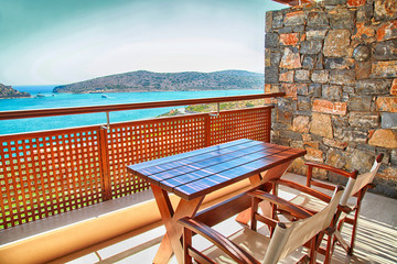 Table and chairs on a balcony with sea view, Greece