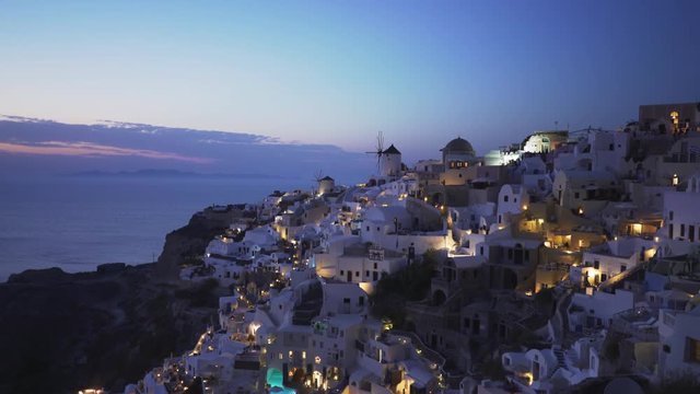 dusk zoom in shot of oia on the island of santorini, greece