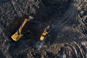 Aerial drone view of excavator loading the tipper truck - obrazy, fototapety, plakaty