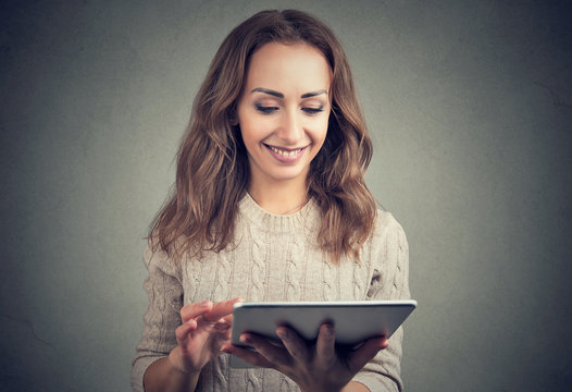 Content girl using tablet on gray backdrop