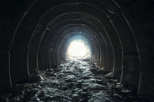 Fototapeta Światło i wyjście na końcu ciemnego długiego tunelu lub korytarza, droga do wolności. Przejście do kopalni kredy przemysłowej z otworem, perspektywa