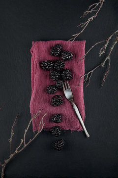 fresh ripe blackberries on a napkin and slate plate kitchen table can be used as background