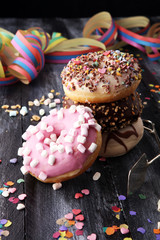 assorted donuts with chocolate frosted, pink glazed and sprinkles donuts.