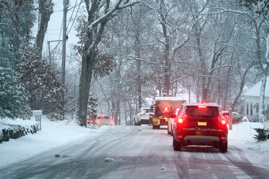 Vehicles stopping on the road after snow in residential area