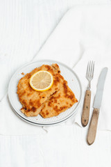 Traditional German or Austrian Wiener Schnitzel or Schnitzel Wiener Art made of breaded and pan-fried butterfly cutlet of pork, veal of chicken meat served with a slice of lemon