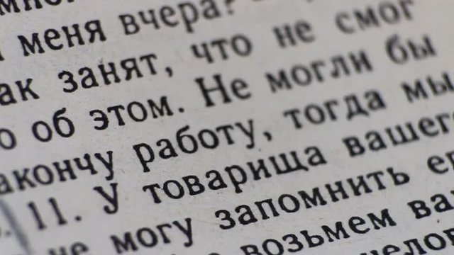 Macro video, page of the book with in print letters is burning. Russian text.