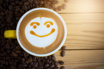 Top view white cup of latte art happy smile face on brown wooden table background