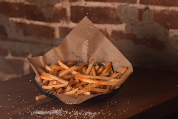 Crispy French Fries in a Basket with Sprinkled Salt