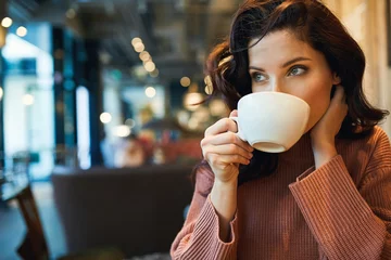 Zelfklevend Fotobehang woman drinking coffee in a cafe © Izabela Magier