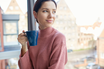 Positive woman with a cup of coffee. Time for break