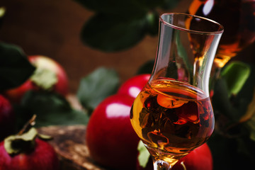 French apple strong alcoholic drink, still life in rustic style, vintage wooden background,...