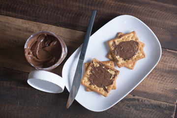 chocolate hazelnut spread on a cream cracker biscuit. food concept