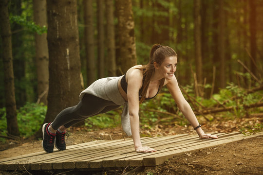 The girl is engaged in fitness in the forest. Sport in the forest