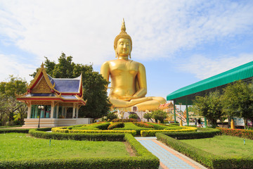 The large golden Buddha statue at Wat Muang against a clouds and blue sky.