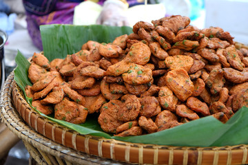 Pile of fried fish patty in the bamboo tray with banana leaf