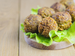 Freshly made falafel on a salad leaf on a cutting Board on a brown wooden table.