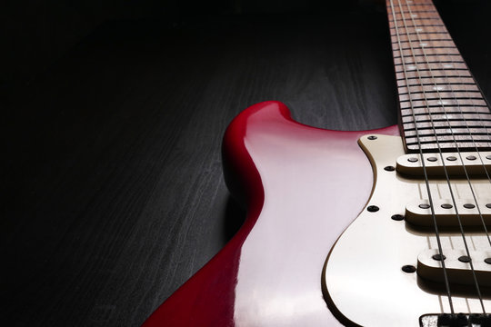 Close up of Electric guitar body and neck detail on black background.