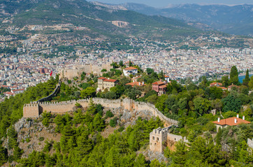 Fototapeta na wymiar Beautiful sea landscape of Alanya Castle in Antalya district, Turkey. Ancient castle in the background of mountains. Summer bright day and sea shore. Kizil Kule (Red Tower) in Alanya, Antalya, Turkey