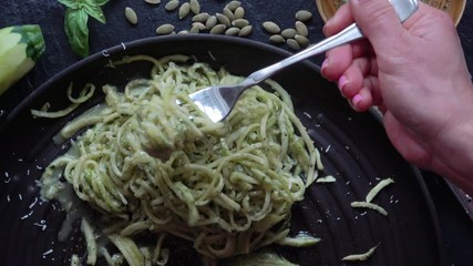 Eating Healthy Zucchini Noodles. Spaghetti noodles made out of Zucchini is called "Zoodles", a fad amongst healthy eaters. This dish is served up with pesto and  parmigiano reggiano.