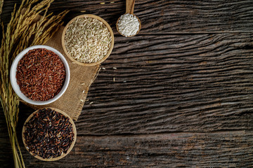 Brown rice, Black Jasmine rice, Red jasmine rice and Riceberry in bowl on black desk. Free space for your text.