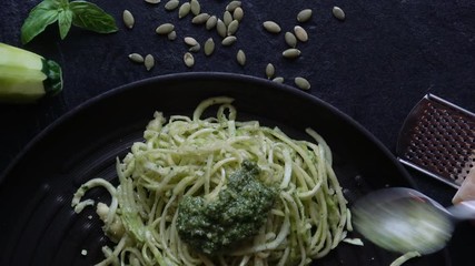 Eating Healthy Zucchini Noodles. lSpaghetti" noodles made out of Zucchini is called "Zoodles", a fad amongst healthy eaters. This dish is served up with pesto and  parmigiano reggiano.