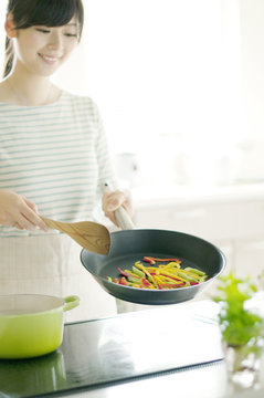 IHキッチンで料理をする女性