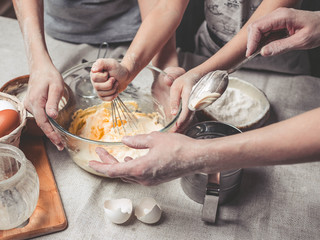 Mothers and children's hands cook dough for home-made cookies. We cook in kitchen together with children. Happy family