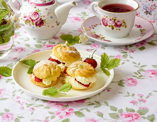 Cream puff cakes with berries on a table