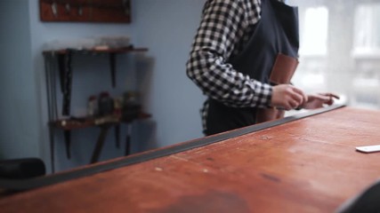 Tanner working in the Studio with the workpiece for the manufacture of leather belt