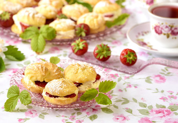 Cream puff cakes with berries on a table
