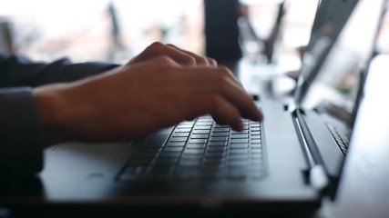 Camera slides around freelancer's hands typing on laptop keyboard in cafe. Businessman working at office with internet. Man searches new job on internet at coffeeshop. Business concept. - Powered by Adobe