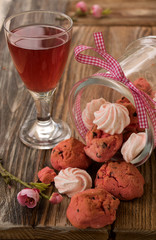 Rosa Kekse mit Baisers in einem Glas und ein Obstsaft