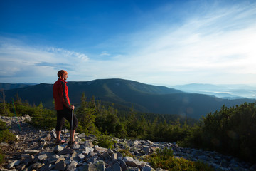 Fototapeta premium Traveler stands on a stony mountain range