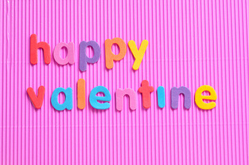 Happy valentine in colorful letters on a pink background