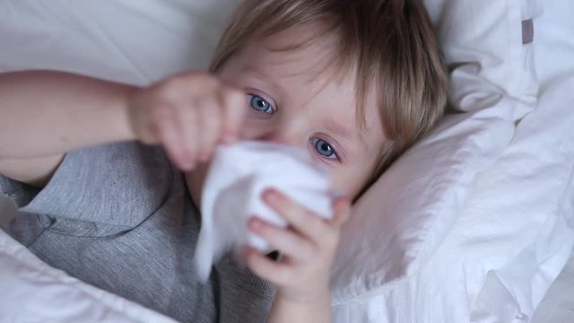Sick two years old child boy on the bed at home - coughing and flaunt