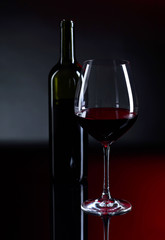 Glass and bottle of red wine.